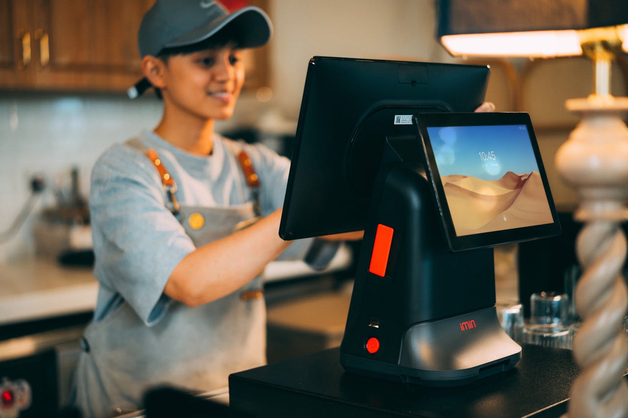 heros-img A cashier using a modern point of sale terminal in a store.