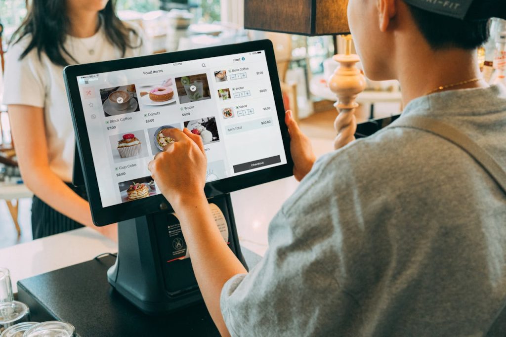 pexels photo 12935048 A customer using a touch screen system at a cafe counter for modern payment processing.