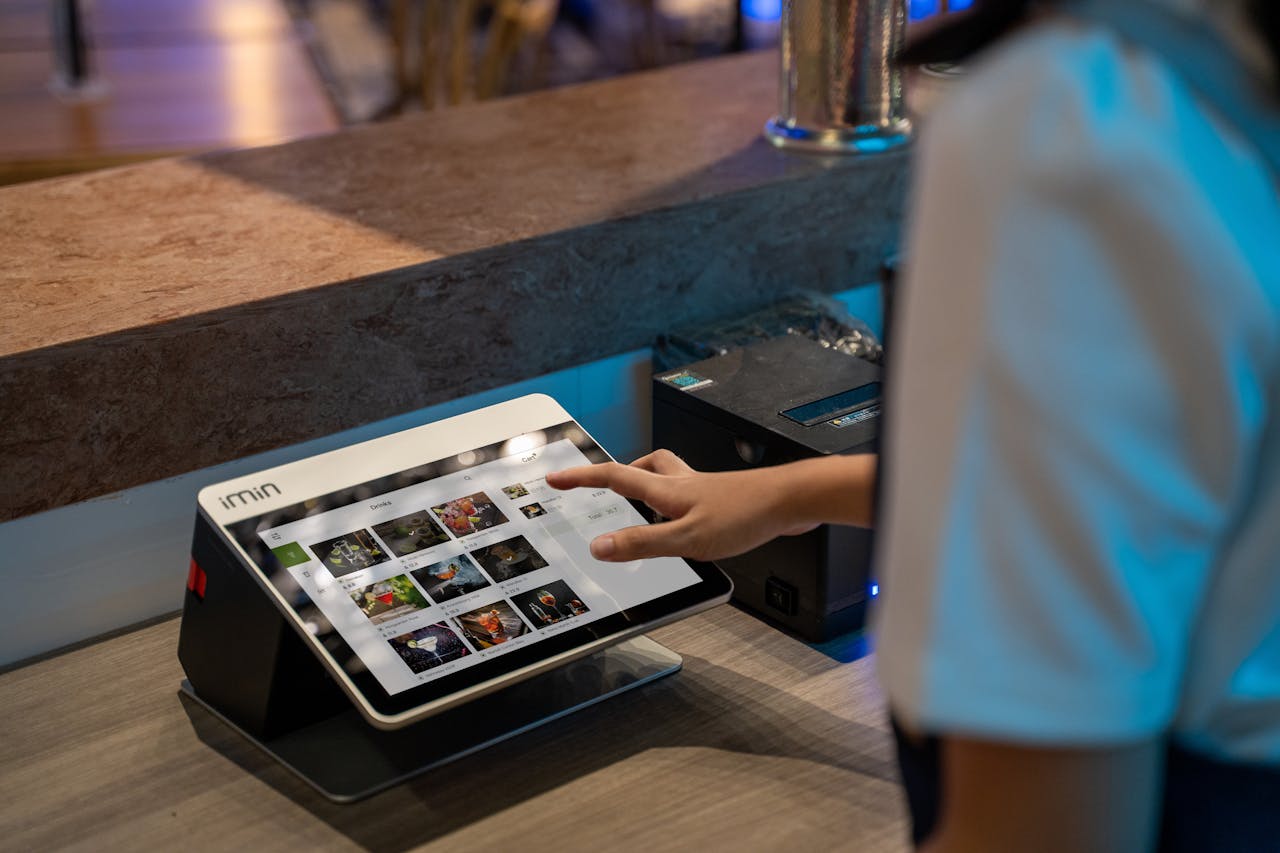 services-02 A close-up of a person interacting with a touchscreen in a restaurant setting, showcasing modern technology.