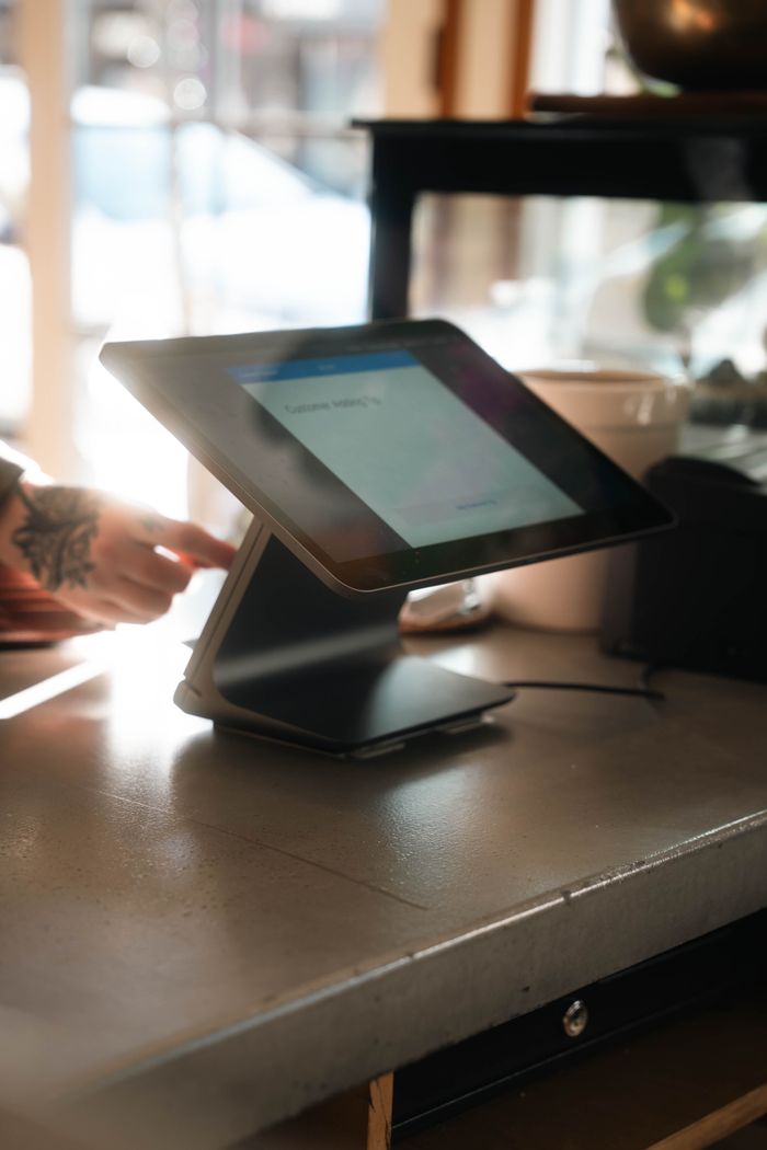 about-us-02 A sleek tablet point-of-sale system in a stylish coffee shop environment.